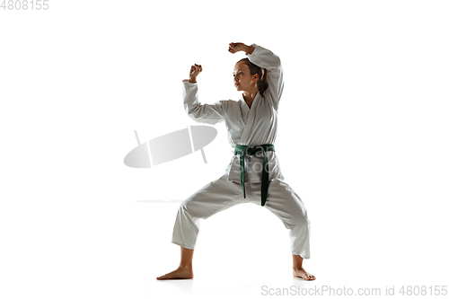 Image of Confident junior in kimono practicing hand-to-hand combat, martial arts