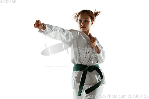 Image of Confident junior in kimono practicing hand-to-hand combat, martial arts