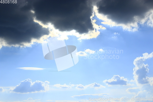 Image of dark clouds on blue sky background