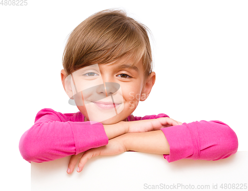 Image of Little girl is looking out from the blank banner