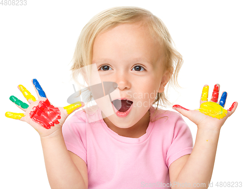 Image of Portrait of a cute little girl playing with paints