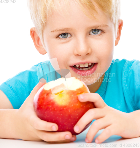 Image of Portrait of a cute little boy with red apple