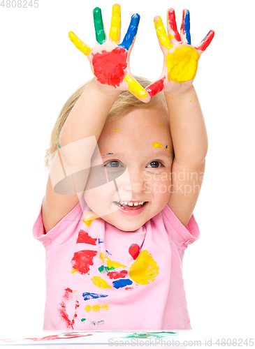 Image of Portrait of a cute little girl playing with paints