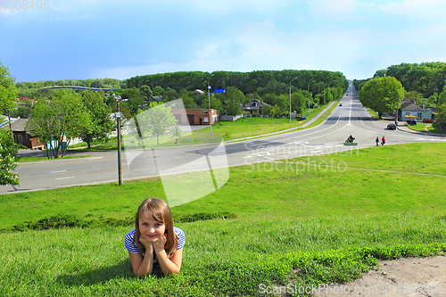 Image of little girl lies on the grass