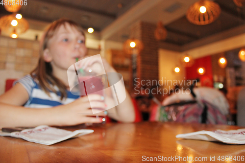 Image of young girl drinks a lemonade