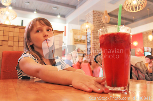 Image of young girl drinks a lemonade