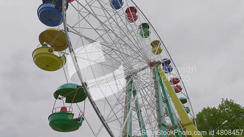 Image of Underside view of a ferris wheel over blue sky.