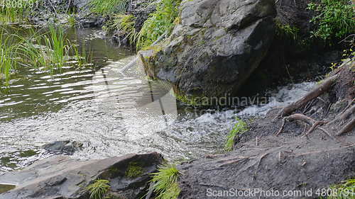 Image of Big beautiful waterfall flows down the rocks mountains