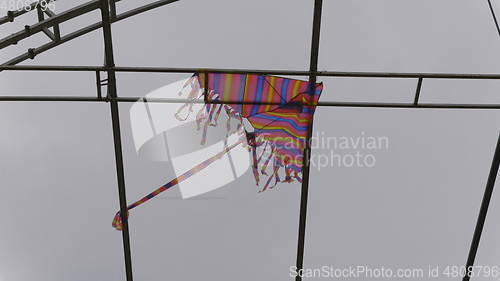 Image of Kite is stuck in the metal structure against the sky.