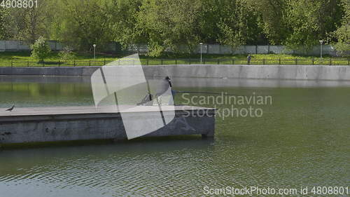 Image of Fisherman catches fish in the lake with a fishing rod.