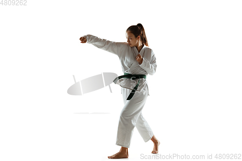 Image of Confident junior in kimono practicing hand-to-hand combat, martial arts