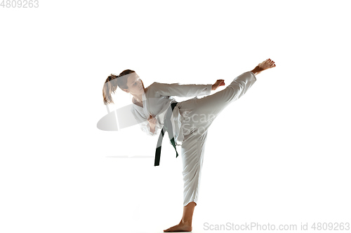 Image of Confident junior in kimono practicing hand-to-hand combat, martial arts