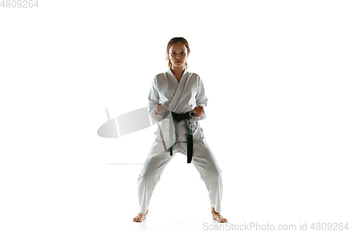 Image of Confident junior in kimono practicing hand-to-hand combat, martial arts