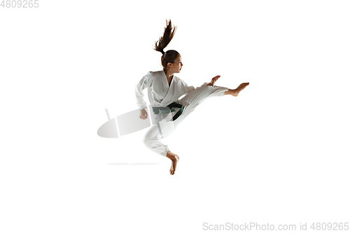 Image of Confident junior in kimono practicing hand-to-hand combat, martial arts