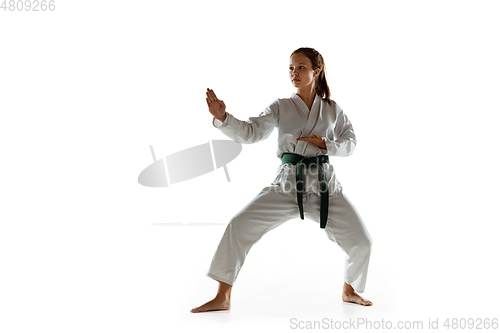 Image of Confident junior in kimono practicing hand-to-hand combat, martial arts