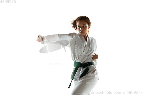 Image of Confident junior in kimono practicing hand-to-hand combat, martial arts