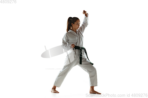 Image of Confident junior in kimono practicing hand-to-hand combat, martial arts