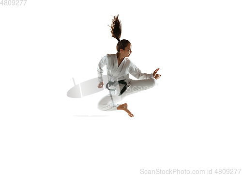 Image of Confident junior in kimono practicing hand-to-hand combat, martial arts