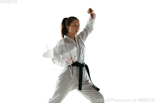 Image of Confident junior in kimono practicing hand-to-hand combat, martial arts