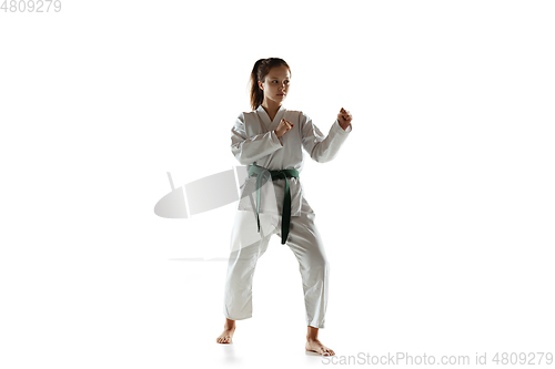 Image of Confident junior in kimono practicing hand-to-hand combat, martial arts