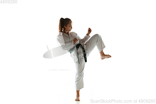 Image of Confident junior in kimono practicing hand-to-hand combat, martial arts