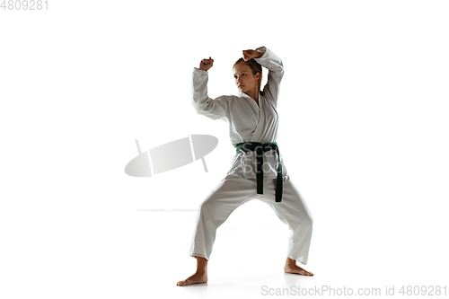 Image of Confident junior in kimono practicing hand-to-hand combat, martial arts