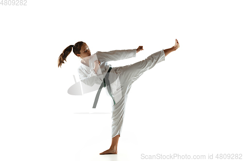 Image of Confident junior in kimono practicing hand-to-hand combat, martial arts