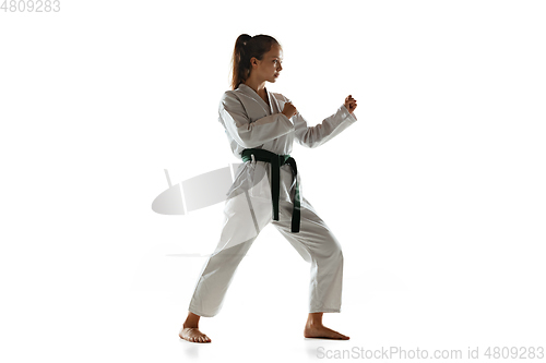 Image of Confident junior in kimono practicing hand-to-hand combat, martial arts