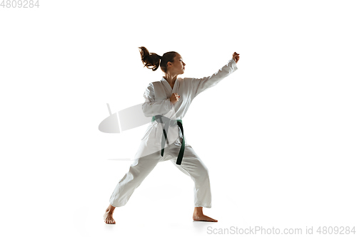 Image of Confident junior in kimono practicing hand-to-hand combat, martial arts