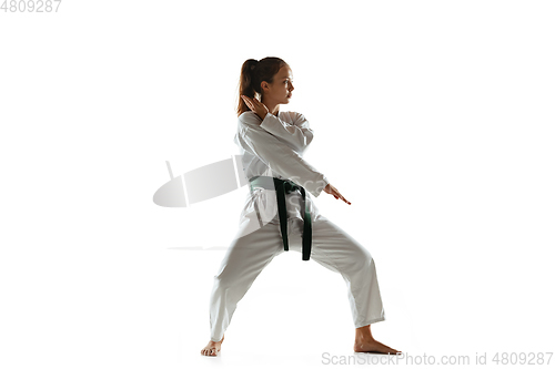 Image of Confident junior in kimono practicing hand-to-hand combat, martial arts