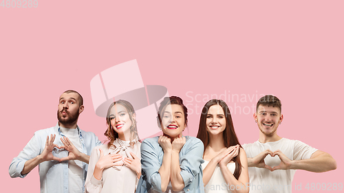 Image of Portrait of multiethnic group of young people isolated on pink studio background, flyer, collage