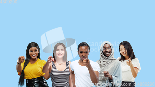 Image of Portrait of multiethnic group of young people isolated on blue studio background, flyer, collage