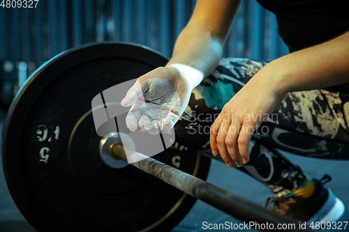 Image of Caucasian teenage girl practicing in weightlifting in gym