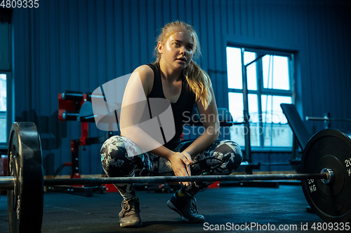 Image of Caucasian teenage girl practicing in weightlifting in gym