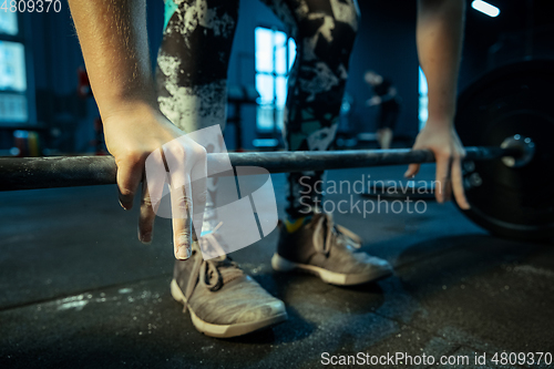 Image of Caucasian teenage girl practicing in weightlifting in gym