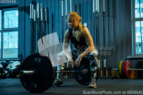 Image of Caucasian teenage girl practicing in weightlifting in gym