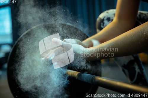 Image of Caucasian teenage girl practicing in weightlifting in gym