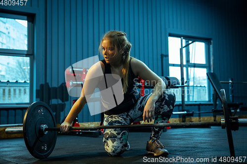 Image of Caucasian teenage girl practicing in weightlifting in gym