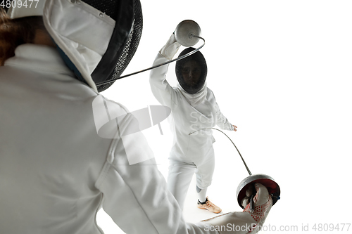 Image of Teen girls in fencing costumes with swords in hands isolated on white background