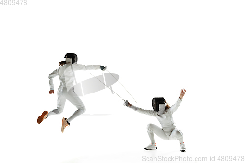 Image of Teen girls in fencing costumes with swords in hands isolated on white background