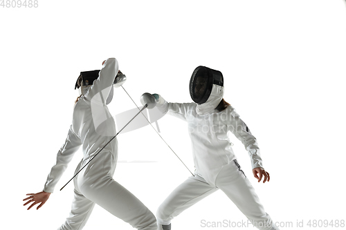 Image of Teen girls in fencing costumes with swords in hands isolated on white background