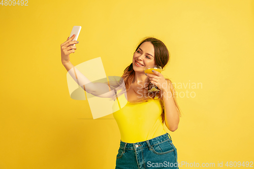 Image of Caucasian woman\'s portrait isolated on yellow studio background