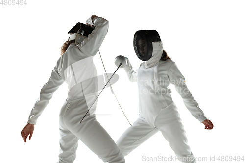 Image of Teen girls in fencing costumes with swords in hands isolated on white background