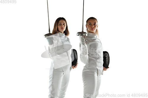 Image of Teen girls in fencing costumes with swords in hands isolated on white background