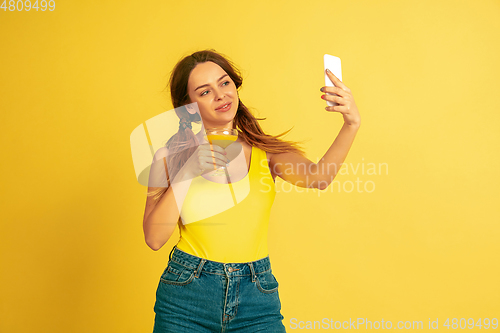 Image of Caucasian woman\'s portrait isolated on yellow studio background