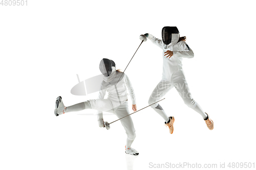 Image of Teen girls in fencing costumes with swords in hands isolated on white background