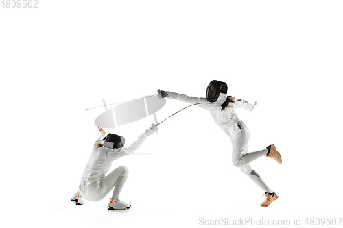 Image of Teen girls in fencing costumes with swords in hands isolated on white background