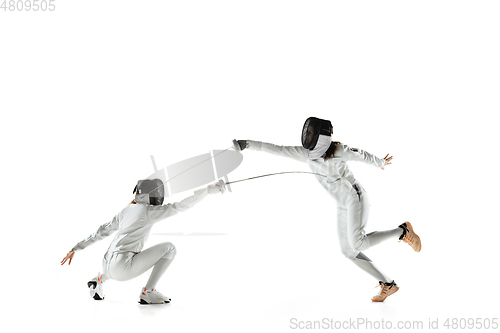 Image of Teen girls in fencing costumes with swords in hands isolated on white background