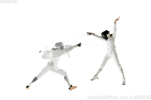 Image of Teen girls in fencing costumes with swords in hands isolated on white background