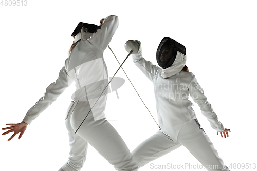 Image of Teen girls in fencing costumes with swords in hands isolated on white background